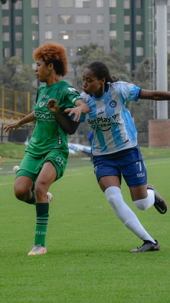A dynamic capture of two women soccer players competing on the field during a match.