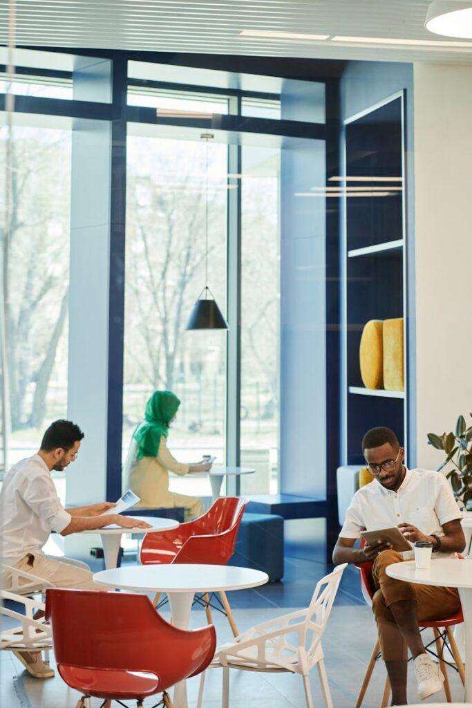 A group of diverse individuals working and relaxing in a contemporary coffee shop setting.