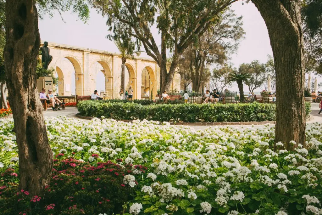 Lush garden with flowers and people enjoying Upper Barrakka Gardens' scenic view, perfect for travel inspiration.