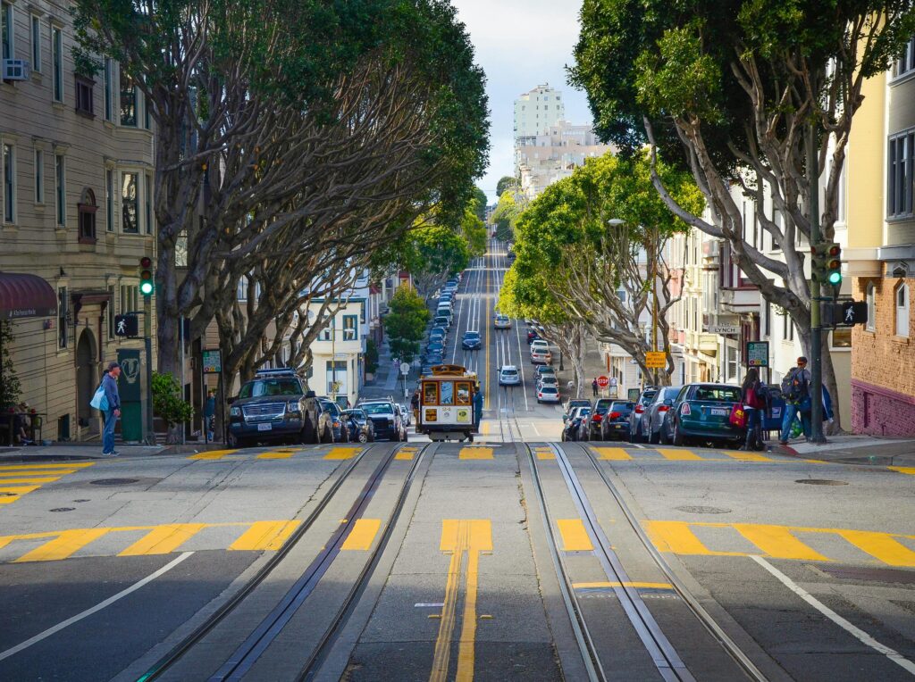 A vibrant city street in San Francisco featuring a classic cable car and iconic architecture.