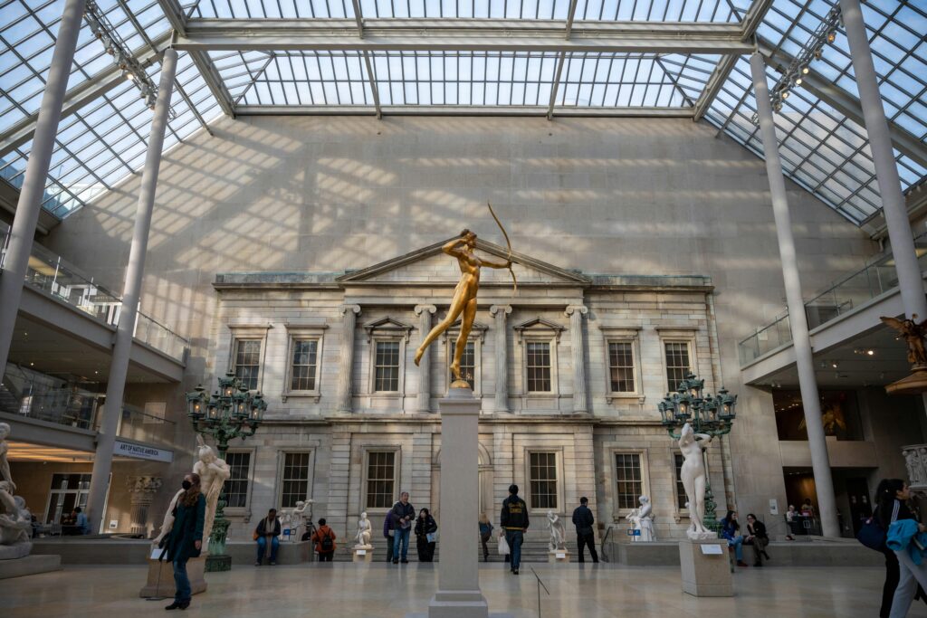 Elegant interior shot of The Met's sculpture gallery showcasing classical architecture and sculptures.