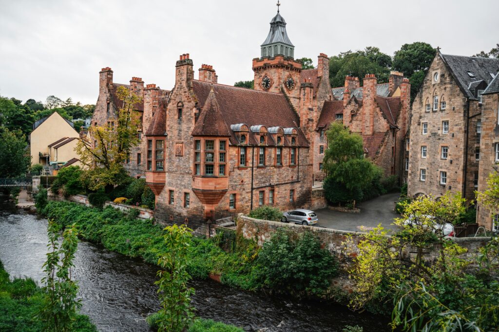 Charming historic buildings by a river in Scotland, showcasing architectural elegance and scenic landscape.