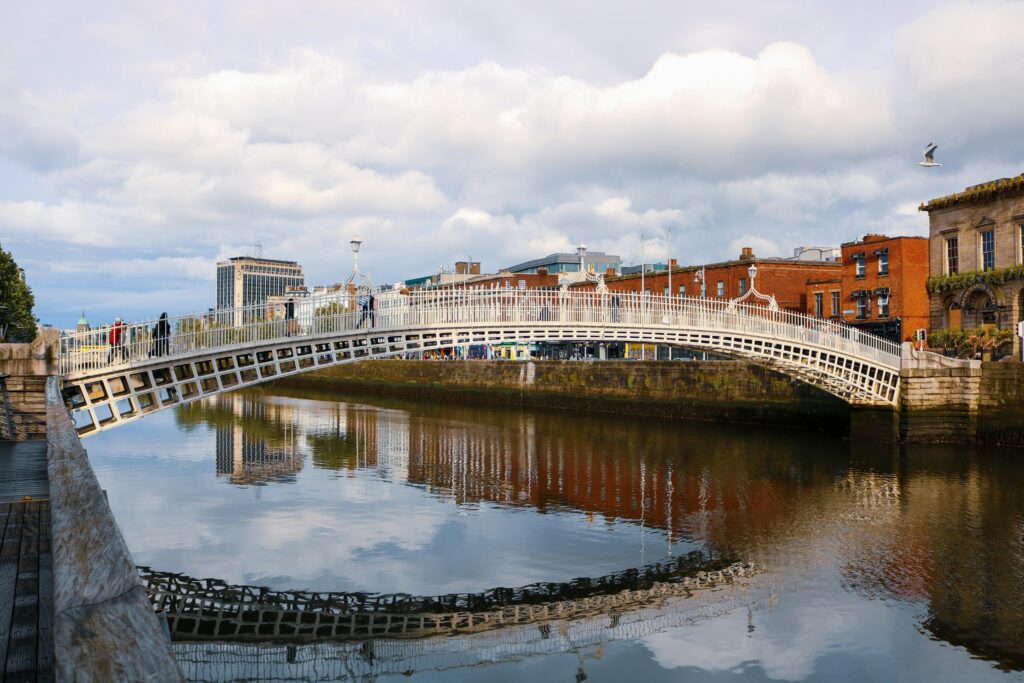 Stunning view of Ha'penny Bridge spanning the River Liffey in Dublin, reflecting in the water.