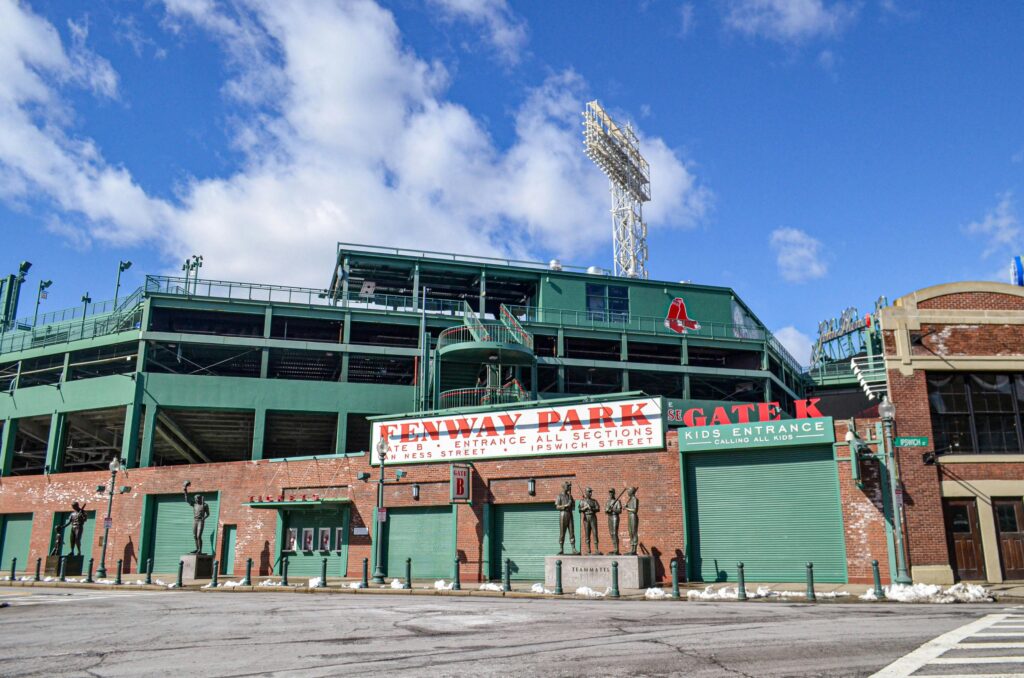 Iconic Fenway Park entrance on a clear day in Boston, showcasing historic architecture and vibrant atmosphere.