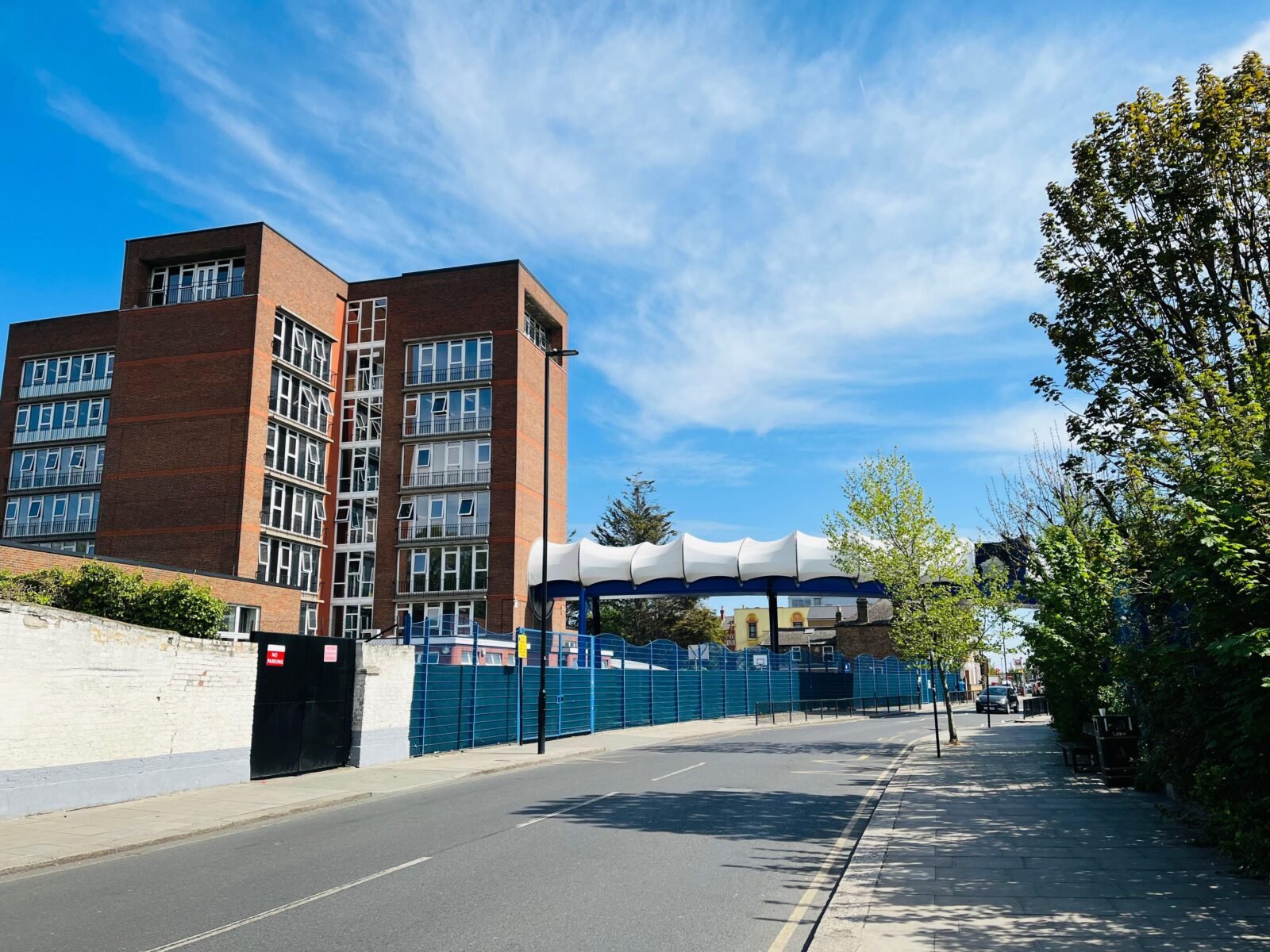 Bright modern residential building on a sunny day in Greater London, showcasing architectural design.